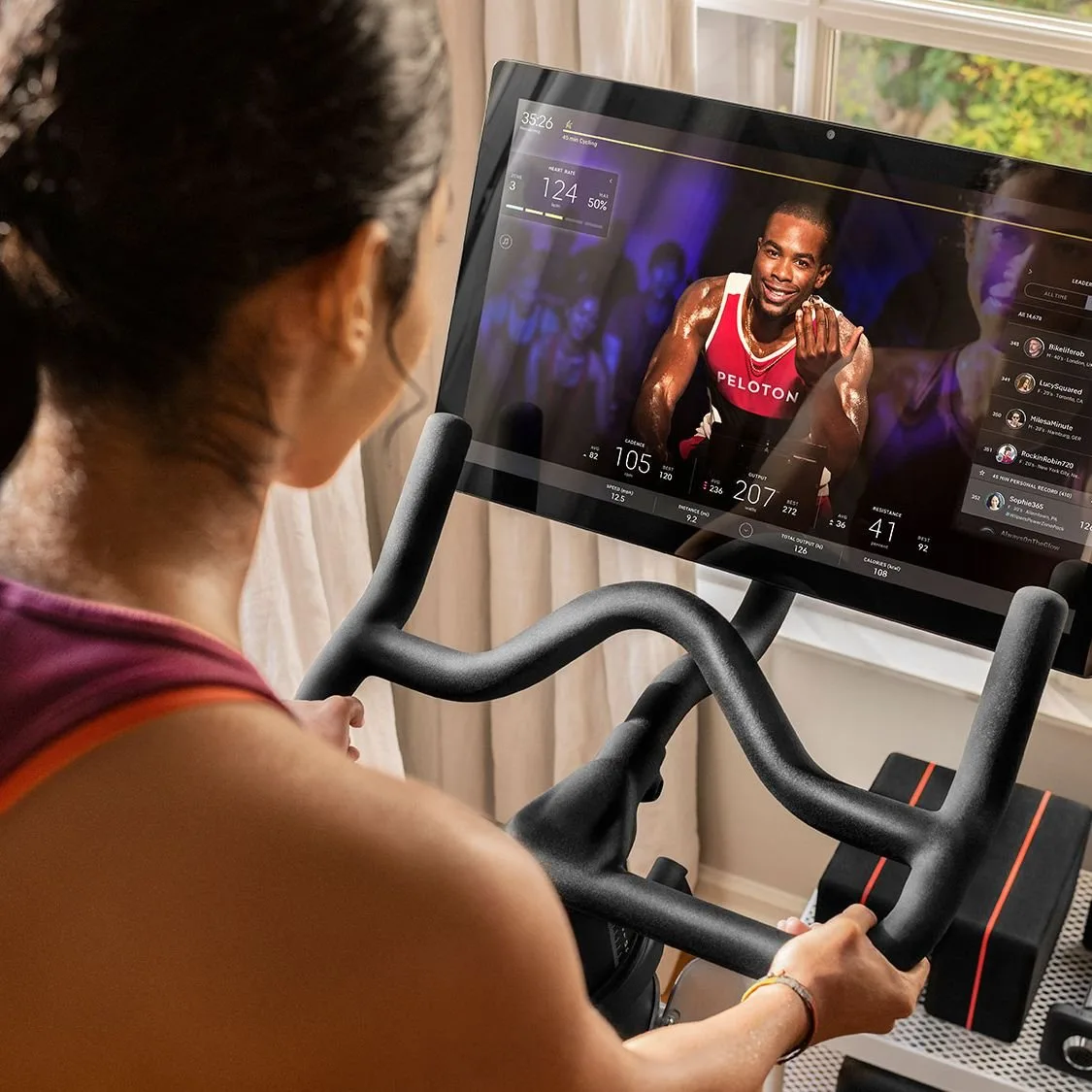 An organized home gym space with a stationary bike and a digital device.