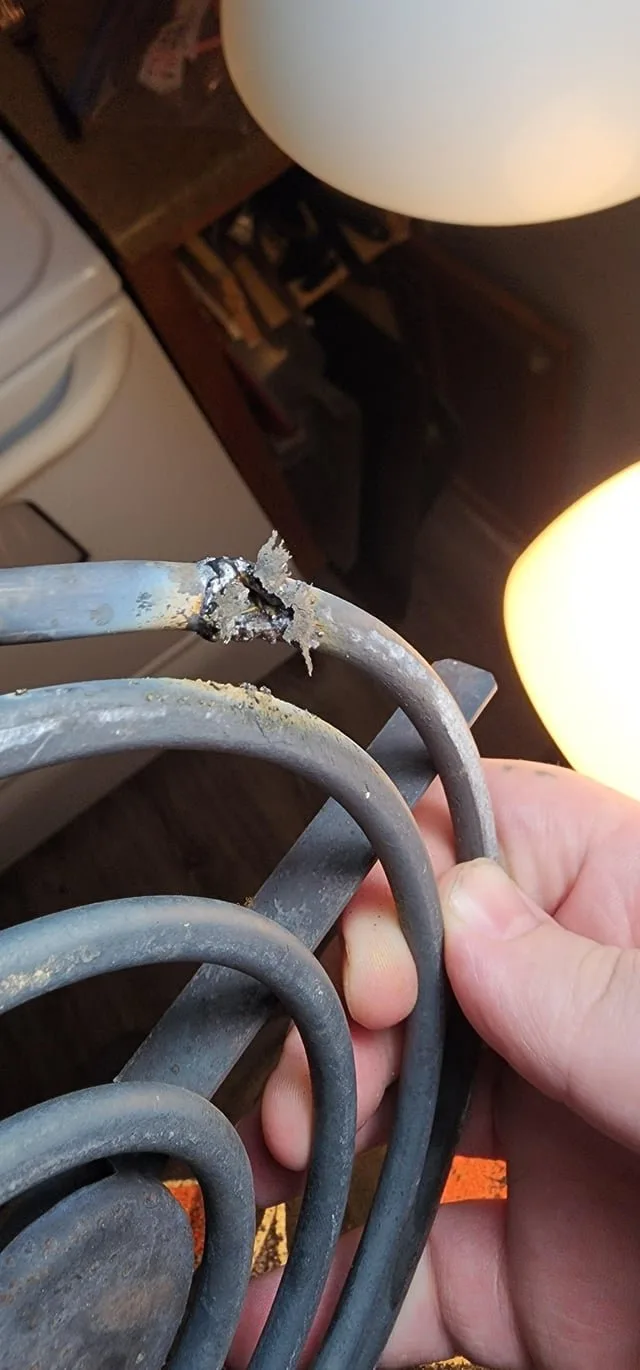 Essential tools for troubleshooting an electric oven heating element laid out on a counter.