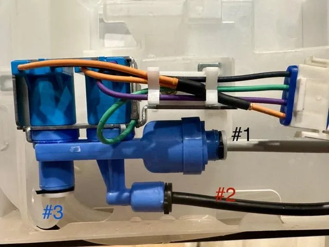 Using a hairdryer to thaw a frozen water line on a refrigerator.