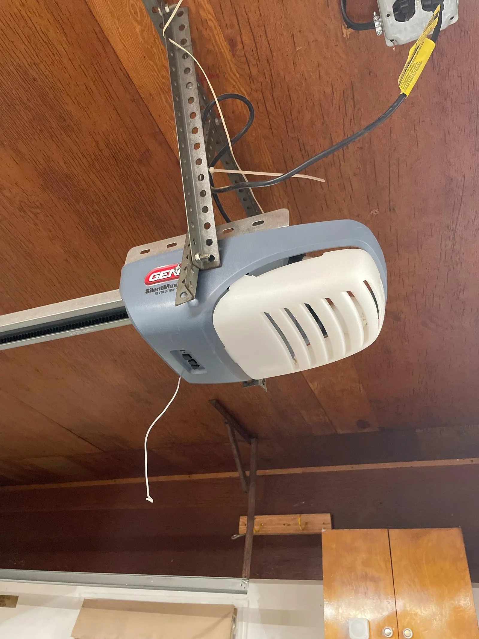 Hand unplugging the power cord of a garage door motor unit.