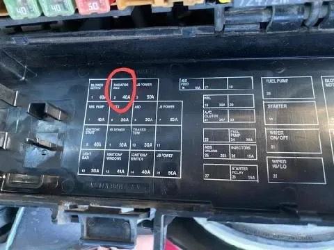 Checking the coolant reservoir level under the hood of a Jeep Liberty.