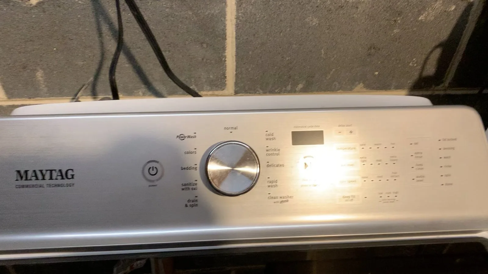 A clean laundry room setup with folded towels on a washing machine.