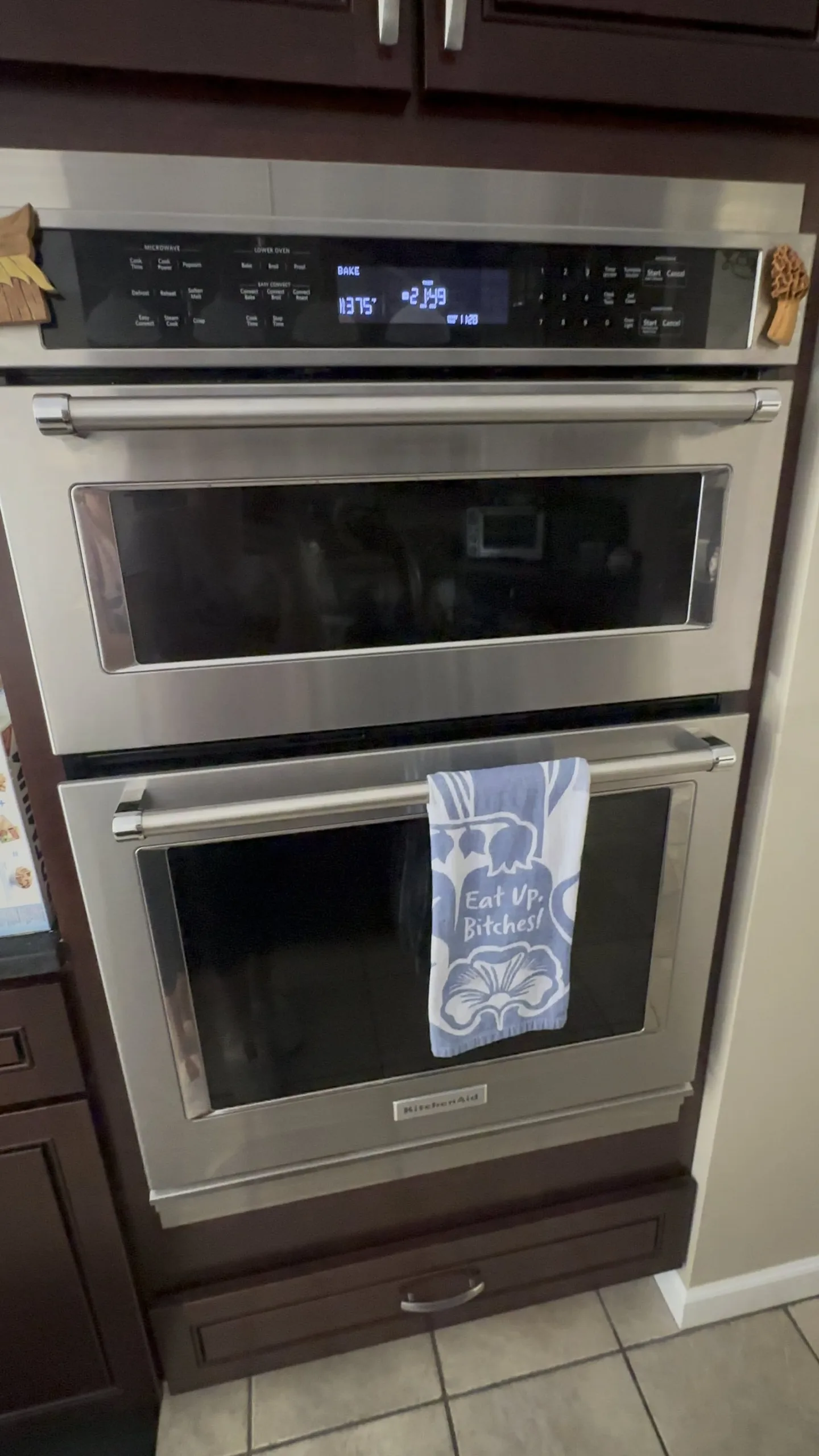 A person reading a manual to solve oven issues in a kitchen.